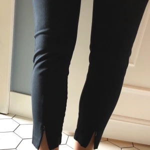 Byxor med dragkedja - Byxor med hög midja och ankellängd. Fin detalj i en dragkedja framtill vid benslut. Köparen betalar frakten.