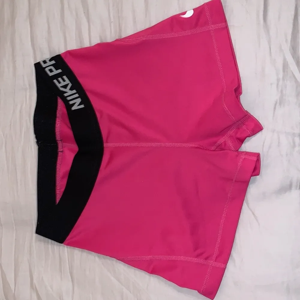 Rosa tränings shorts från Nike i bra kvalitét, lite skadad på själva Nikemärket på sidan men så blir det alltid med deras kläder efter några tvättar. Säljer för att jag inte får någon användning av de<3 Nypris: 300kr. Säljs nu för: 150kr🥰. Shorts.