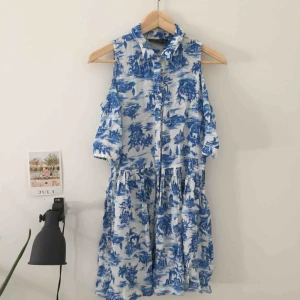  - Klänning med detalj över axlarna, aldrig använd.