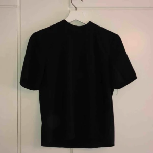  - Svart lite finare tröja av lika material som en blus. Den har en lite längre T-shirt ärm och en silvrig dragkedja i nacken. Det står att det är M men skulle säga att den är som en S 😊 50kr + frakt 