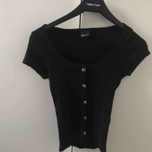  - Frakt ingår ej, t-shirt med knappar till midjan från gina tricot för två år sen.