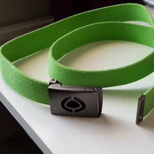  - Grönt tygskärp med spänne. Har några små repor på spännet men annars i fint skick. Fraktkostnad blir 36kr.