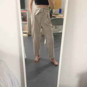  - Randiga byxor i beige och vitt. Hög midja med inbyggt skärp. Bomull. Väldigt sköna o luftiga. Aldrig använda!  Kan mötas upp tallkrogen eller centralt i sthlm.