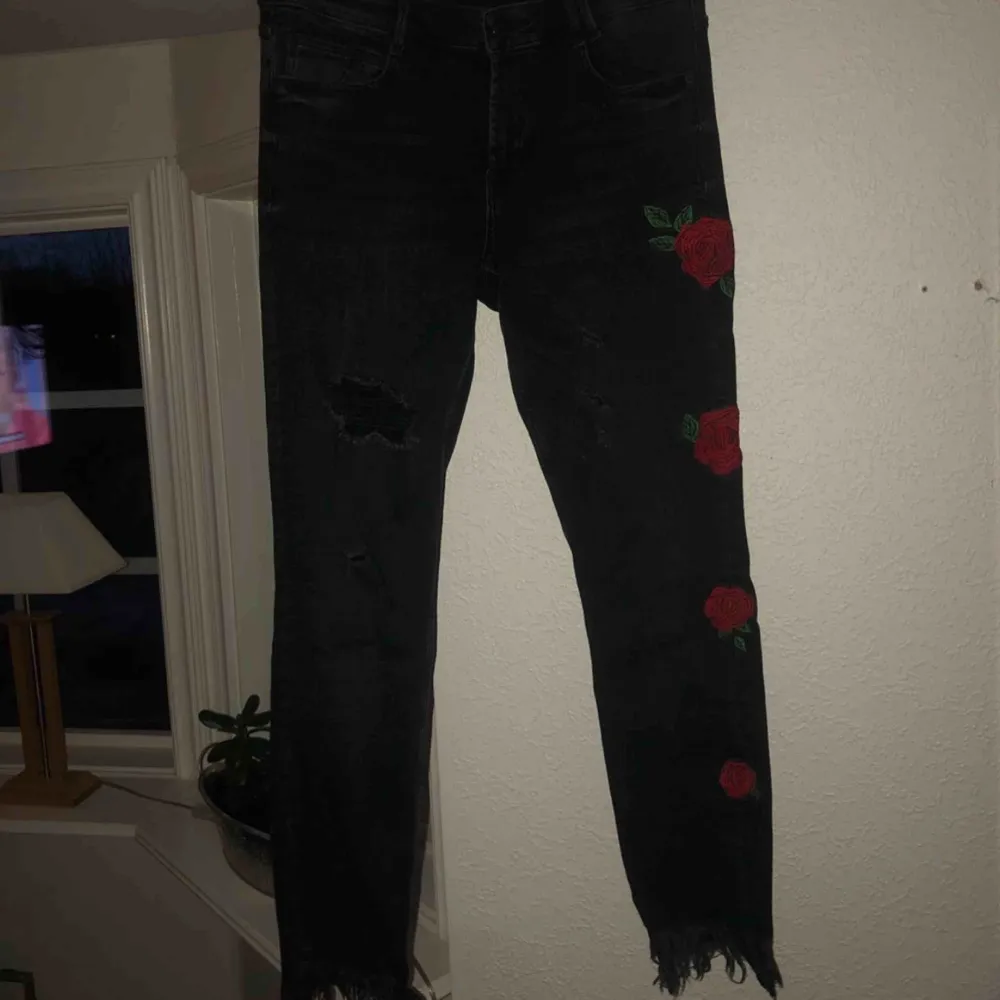 Jeans med slitningar på knäna och blommor på vänsterbenet, från Zara I ganska bra skick. Jeans & Byxor.