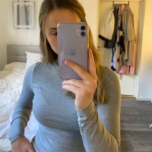  - Grå body med hög krage. Använd en gång. Köparen står för eventuell frakt.