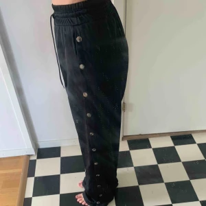  - Snygga byxor/trackpants i glansigt tyg från chiquelle, knappt använda, knappar på sidorna som går att knäppa upp hela vägen :) 63kr frakt tillkommer!