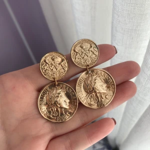 Örhängen - Guldiga örhängen köpta på H&M förra året, använda vid ett tillfälle! De är lite skadade (se bild 2) men inget som syns när man har de på sig!