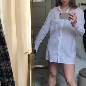 Skjortklänning från Linn Ahlborg X NAKD - En snygg skjortklänning som man kan styla på många olika sätt. Skitsnygg att ha bara som klänning eller som en oversized skjorta till jeans eller uppknäppt över bikinin. Snygga detaljer. Säljer pga. att jag har en annan liknande.