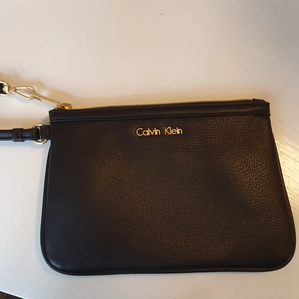 Säljer min äkta Calvin Klein clutch bag då en inte kommer till användning  Den är köpt i USA och är oanvänd   Mått; Längd 20cm Höjd 14cm. Frakt ingår i priset  💌. Väskor.