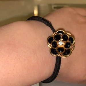 Accessoarer  - En gullig tofs med en svart ros ovan, hårsnodden är lite tunn vid ros delen men den funkar och har inga slags problem. FRI FRAKT