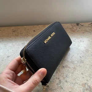 Michael Kors Plånbok  - Säljer en Michael Kors plånbok (som självklart är äkta) och som är använd i något år! Små tecken på användning finns på gulddetaljerna om man kollar noga men i övrigt väldigt gott skick! 👌🏼 Ligger ute på fler sidor, frakt tillkommer 💗
