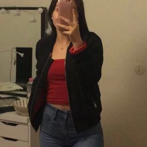 Bomberjacka  - Svart bomberjacka med rött innertyg. Guldiga detaljer. Köpt på Dennis maglic för några år sedan men i bra skick! Stl. S