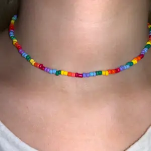 Flerfärgat pärlhalsband med små pärlor💛🧡❤️💜💙💚 halsbandet försluts med lås och tråden är elastisk 