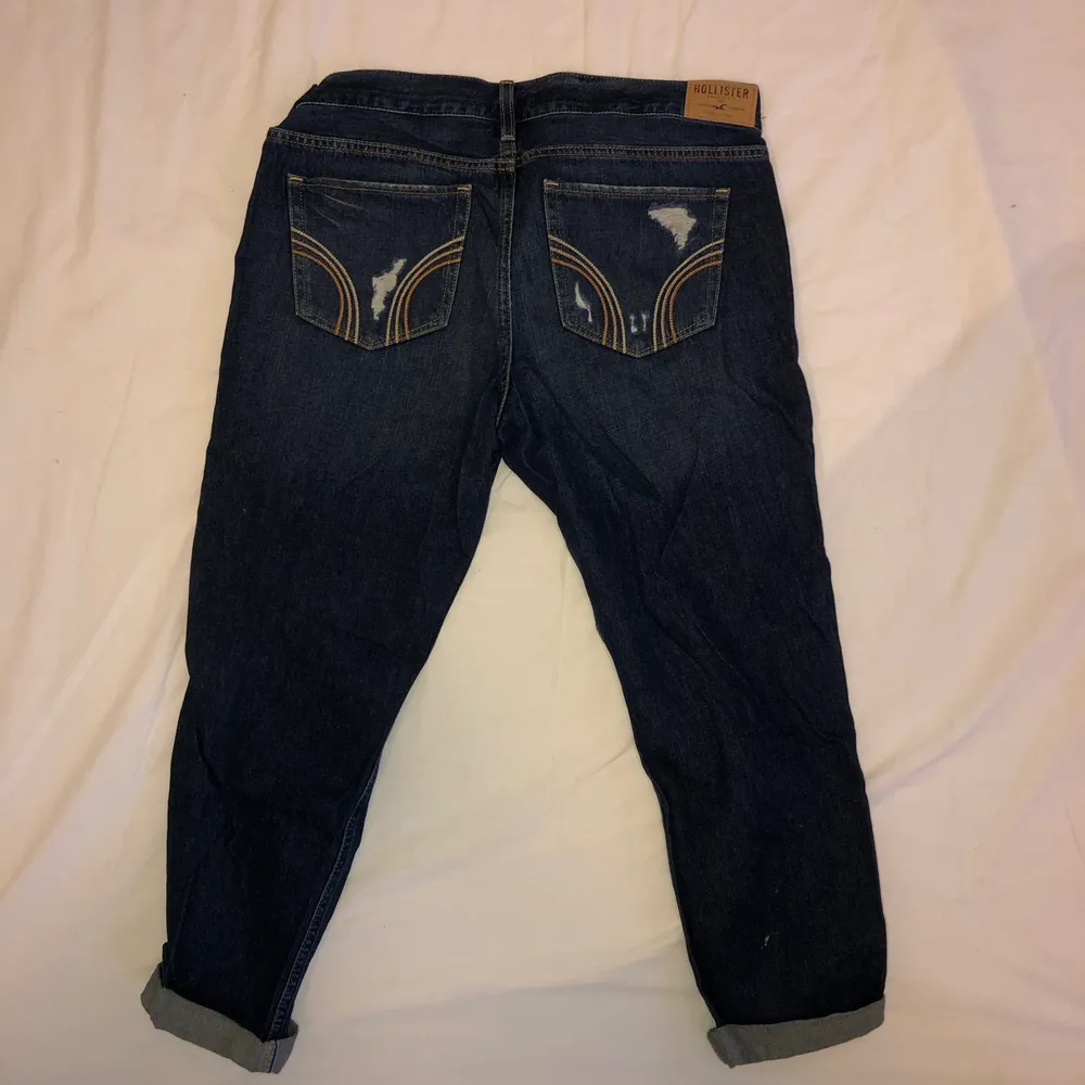 Mörkblåa boyfriend jeans med slitningar från hollister. Står att storleken är W30, men de är rätt korta i modellen. Köparen står för frakten :). Jeans & Byxor.