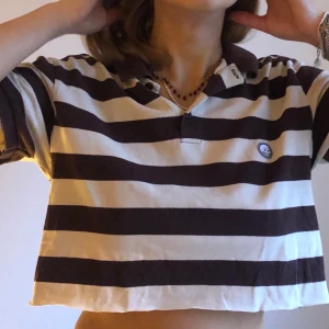 Croppad piké  - Fin avklippta cheap monday piké. Randig i brunt och offwhite. Storlek S. Fint skick!✨✨ frakt tillkommer eller möts upp i Stockholm C