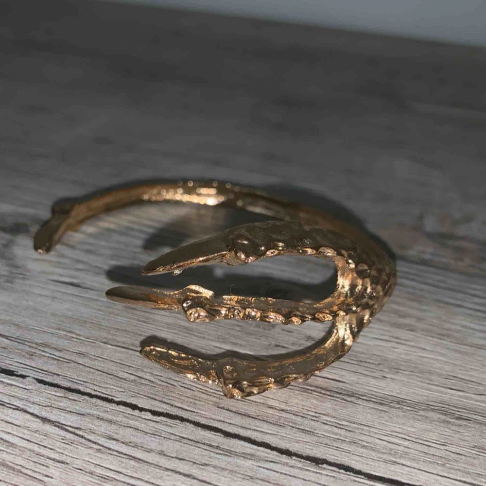 Coolt guldigt armband i hård metall. I formen av någon slags klo:). Accessoarer.