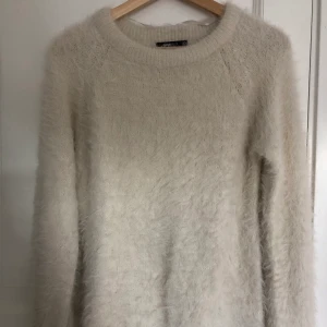Vit fluffig, stickad långärmad tröja i stl S - En supermysig höstig tröja. Inte alls stickig och endast använd 2 gånger. Tröjan är från Ginatricot i storlek S. Passformen är väldigt bra då den följer kroppen fint!