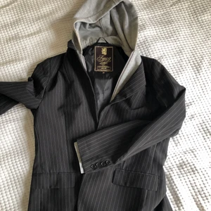 Randig kavaj  - Randig kavaj med insydd luva, storlek M, väl använd men i bra skick. Favorit-kavajen i hemmet 