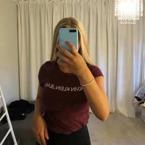 T-shirt - Vinröd calvin klein t-shirt. Se andra bilen för att få en mer rättvis bild av färgen (den är mer vinröd än brun irl) nypris 400kr men säljer för 80kr + frakt. Skriv för mer bilder