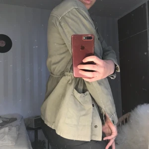 Militärjacka - En militärgrön jacka med fina detaljer. Väldigt tunn så perfekt för vår/sommar! Köparen står för frakten!