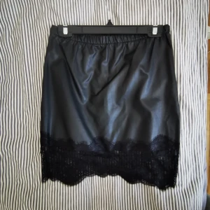 Svart läderkjol - Strl M, från Vila. Använd en gång. Svart läderimitation kjol. 