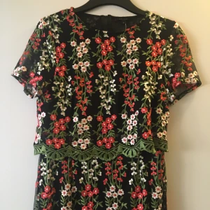 Klänning - Skitfin och lyxig blommig klänning med nättyg som är längre nertill än underklänningen. Helt oanvänd i storlek 36, prislapp hänger kvar men för liten för mig och för fin för att bara hänga i garderoben. Hämtas upp i Sthlm/Sundbyberg. 