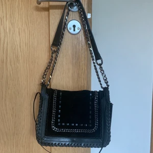 Svart handväska  - Svart väska med coola detaljer från Zara i gott skick. Köpte för 900-1000 kr säljs för 250. Köparen står för frakt. 