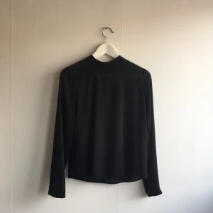  - Superfin svart blus med guldig dragkedja baktill. Aldrig använd!