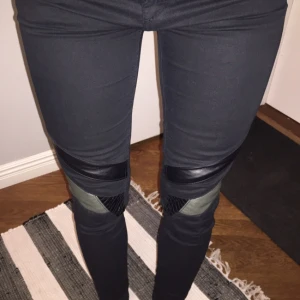  - Svart byxa från Pull & Bear med läderdetaljer i knäna, samt dragkedja längst ner vid foten. Sparsamt använda.