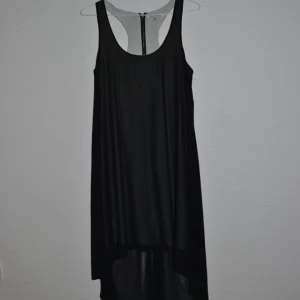  - Svart, superfin klänning. Längre bak, kortare fram. Transparant tyg med undertyg i svart. Köpt på Urban Outfitters