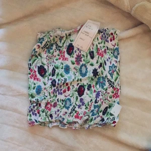  - Top utan ärmar i stretch material. 