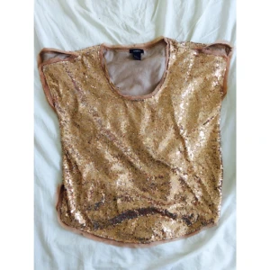  - Paljettopp från Lindex i roséguld. Aldrig använd,storlek m. Toppen har typ slitsar på axlarna,fin detalj! Skickas eller möts i Stockholm.
