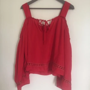  - Röd off-shoulder bohoblus i härligt material med fina detaljer
100 % Polyester