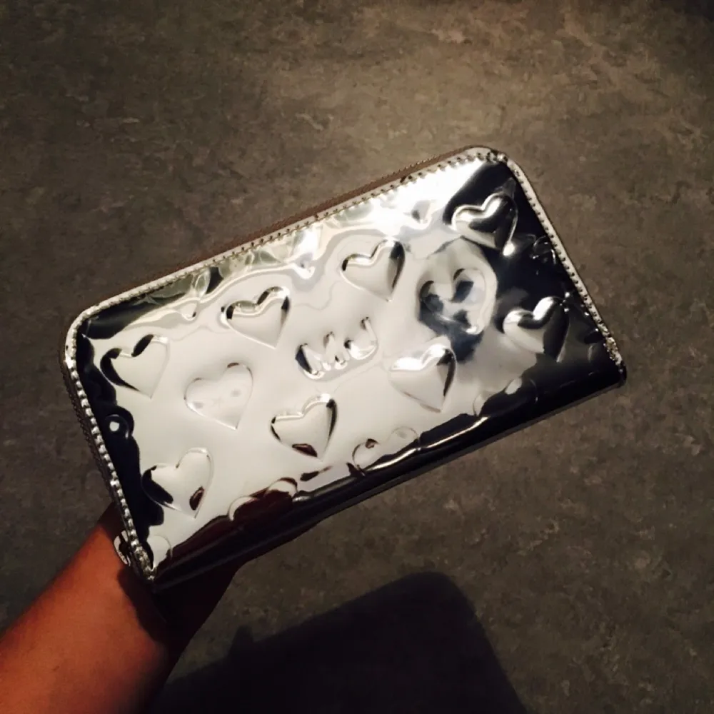 Helt ny äkta Ltd Edition Marc Jacobs plånbok som aldrig kom till användning. Svårt att fota eftersom den är glansig/ spegel effekt. Får plats med 6 kort och har en mynt hållare. 
Mått : B 19cm H 10cm D 2,5cm. Frakt 35kr. . Accessoarer.