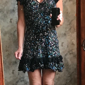 Jättesöt (kort) klänning ca/34 - Bedårande svart klänning med små blommor i rosa/blått, xs/34, använd 1 gång