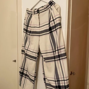 Kostymbyxor rutiga - Unika och moderna kostymbyxor fran Monki i skönt material. Sitter bra på rumpan! ;) lite noppriga mellan låren men går att ta bort. Kan mötas i Sthlm eller så tillkommer fraktkostnad.