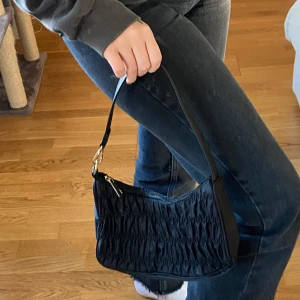 Svart rynkad väska - Snygg svart rynkad väska! Har aldrig använt den utan den har bara hängt på en krok hemma, så kanske ser lite platt ut på bilderna men den är rymligare än vad man ser! Frakt tillkommer💖 