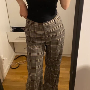 Utsvängda rutiga byxor - De här byxorna sitter bra men de är lite långa i modellen. Storlek 38