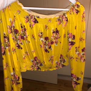 Jättefin gul topp med blommor  - Går ner vid axlarna. Jag är en S och använder den i L. sitter riktigt snyggt 