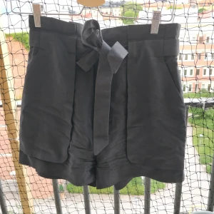 Högmidjade shorts med knyte  - Från Monki. Så bekväma och tunna! Djupa fickor fram och fejkfickor bak. Möts helst upp annars tillkommer frakt. 