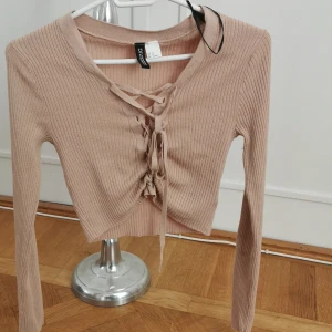 Ribbad tröja  - Jättefin ribbad beige tröja med snörimg, man kan knyta om den så den blir längre eller kortare 😊 testad men säljer för att den fick mig ej att se blek ut haha så köpte vit istället :) är xs men är väldigt stretchig