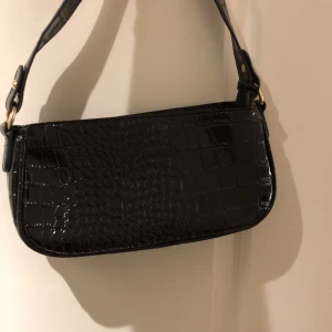 Trendig väska - Trendig svart baguetteväska. Köpt för 200kr. I nyskick, endast använd 1 gång. Säljer pga ingen användning💕 frakt 66kr. Kan tänka mig att pruta på priset