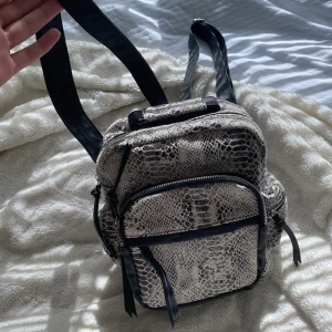 Liten ryggsäck  - Söt liten ryggsäck med ormskinns tryck💕🐍  7 fack totalt😚 använder knappt längre 🥰 öppen till att diskutera pris💕