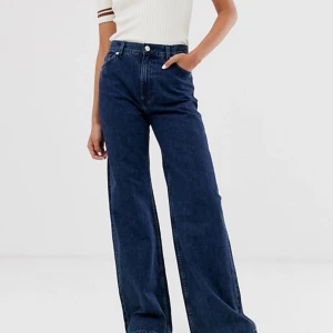 Monki Yoko Wide Leg mörk tvätt - Sparsamt använda och trendiga byxor från monki i w26 men passar en Small. Innerbenslängd: ≈78cm Byxorna kostar 400kr nypris och är väldigt ofta slutsålda. Vid snabbt köp står jag för frakten:)