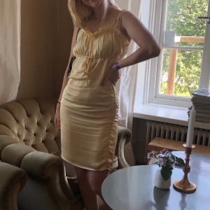 Klänning från nakd - Storlek: M (jag har vanligtvis storlek S). Det är en gul Satinklänning med dragkodsdetalj