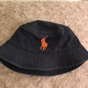 - Ralph Lauren Bucket hat i blått "jeans" tyg med oranget märke. 