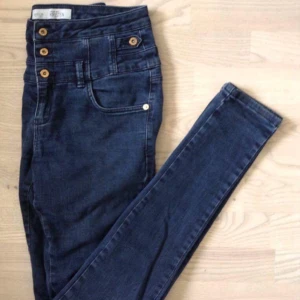  - Mörkblå jeans från Topshop med hög midja och guldiga knappar.