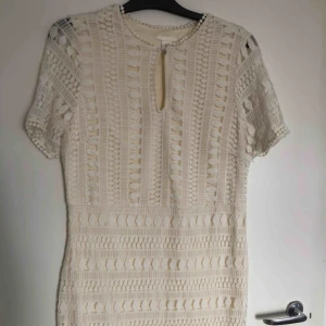  - Jättefin vit medellång spetsklänning. Figursydd passform, men ändå rymlig. Perfekt till studenten! Använd ett fåtal gånger. I storlek 44