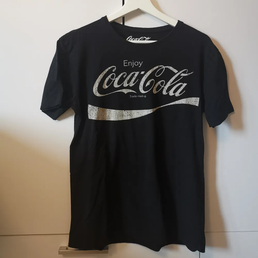Svart T-shirt med Coca-Cola tryck i storlek M. Frakten ligger på 44 kr. . T-shirts.