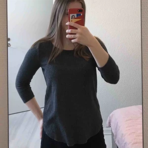  - Grå topp med trekvartsärm från Ginatricot, storlek XS. Fint skick, lite nopprig. Fraktkostnad tillkommer